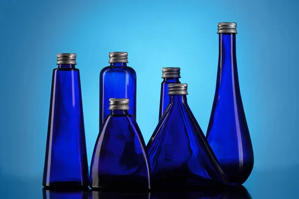 Kleine Blauwe Flesjes Een Gradiënt Achtergrond — Stockfoto