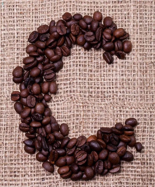Kahve çekirdekleri kumaş çuvalının üstünde.
