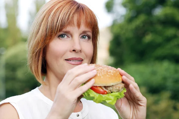 Retrato Uma Mulher Atraente Que Está Comendo Hambúrguer Parque — Fotografia de Stock