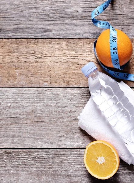 Masada bir şişe su ve portakal var.