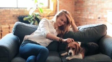 Evde köpekle oynayan güzel genç bir kadın.