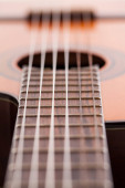 Detailní záběr akustické kytary na hmatníku