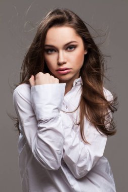 Gri arka planda yabancılaşma duygusu olan genç bir kadın.