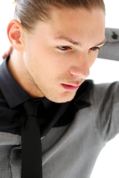 Beyaz arka planda poz veren takım elbiseli yakışıklı bir adamın portresi.