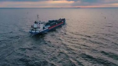 Gün batımında kargo gemisinin deniz manzarası. 