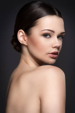 Gri arka planda sevimli, çekici bir kadın.