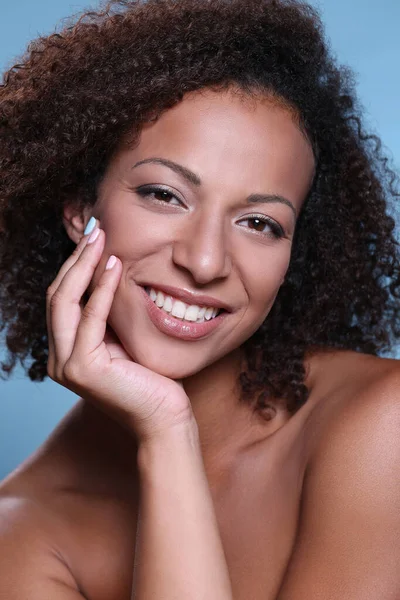 Güzellik, cilt bakımı. Mavi arka planda güzel bir kadın