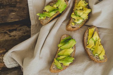 Tahta bir masada nefis avokado sandviçi.