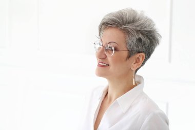 Sevimli, yaşlı ve mutlu yüzlü bir kadın.