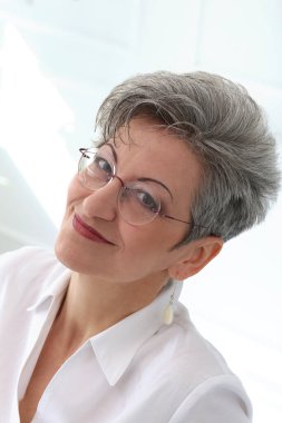 Güzel gülüşü olan tatlı, yaşlı bir kadın.