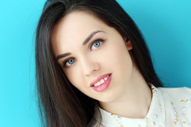 Mavi arka planda sevimli, çekici bir kadın.