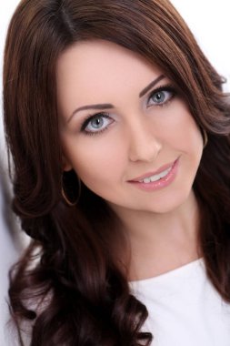 Beyaz arka planda gülümseyen tatlı bir kadın.