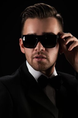 Siyah takım elbiseli çekici bir adam ve kelebek.