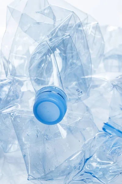 Yararlanma. Boş, ezilmiş su şişesi beyaz arka planda