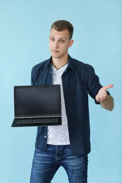 stock image Handsome man with laptop on a blue background