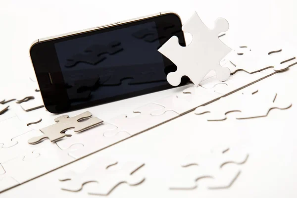 Białe Puzzle Telefonem Komórkowym Stole — Zdjęcie stockowe