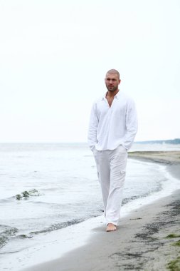 Sahilde çekici ve mutlu bir adam.