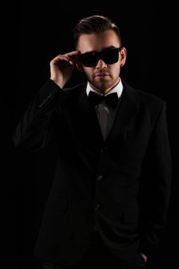 Siyah takım elbiseli çekici bir adam ve kelebek.