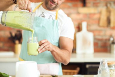 Mutfak. Mutfakta mavi önlüklü bir adam.