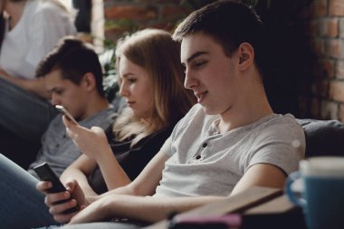 Eğleniyor ve akıllı telefonlar evde kullanma genç grup