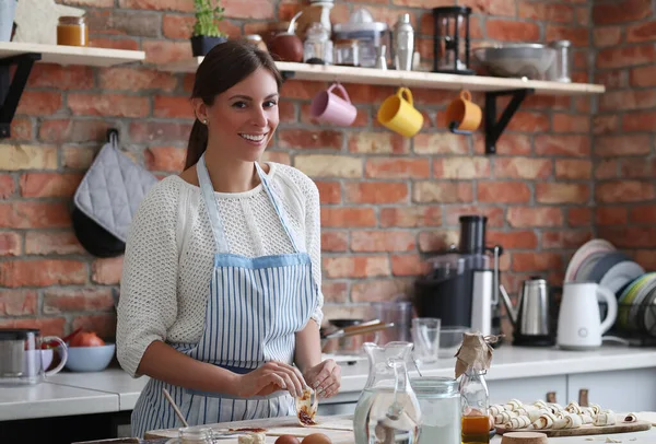 Genç ve güzel bir kadın mutfakta yemek pişiriyor. El yapımı yemek.