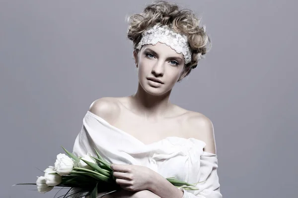 美しい若い女性は灰色の背景上の白いチューリップ — ストック写真