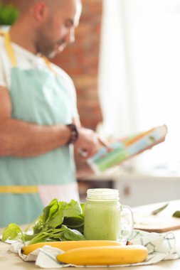 Mutfak. Mutfakta mavi önlüklü bir adam.