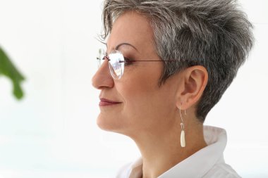 Sevimli, yaşlı ve mutlu yüzlü bir kadın.