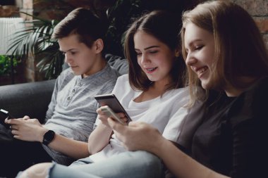 Eğleniyor ve akıllı telefonlar evde kullanma genç grup
