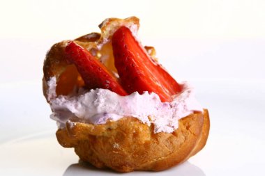 Krema ve çilekle dolu lezzetli profiterol.