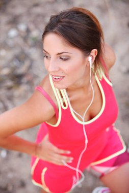 Genç ve güzel kulaklıklı fitness kızı.