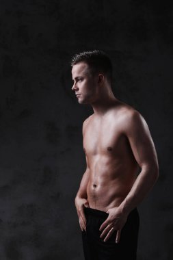 Beton duvarda gömleksiz bir adam.