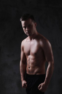 Beton duvarda gömleksiz bir adam.