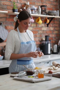 Genç ve güzel bir kadın mutfakta yemek pişiriyor. El yapımı yemek.