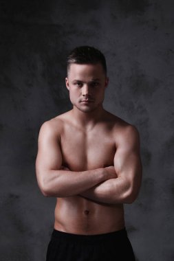 Beton duvarda gömleksiz bir adam.