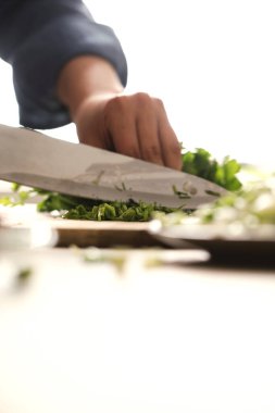 Yemek pişirmek. Şef mutfakta sebze kesiyor.