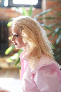 Pembe gömlekli orta yaşlı kadın.