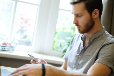 genç erkek serbest meslek sahibi Online kafede dizüstü kullanma ve içme kahve sohbet