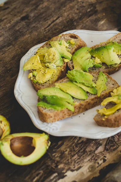 Tahta bir masada nefis avokado sandviçi.