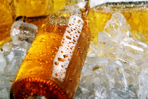 Buz içinde yatan soğuk bira şişeleri. Yakın görünüm.