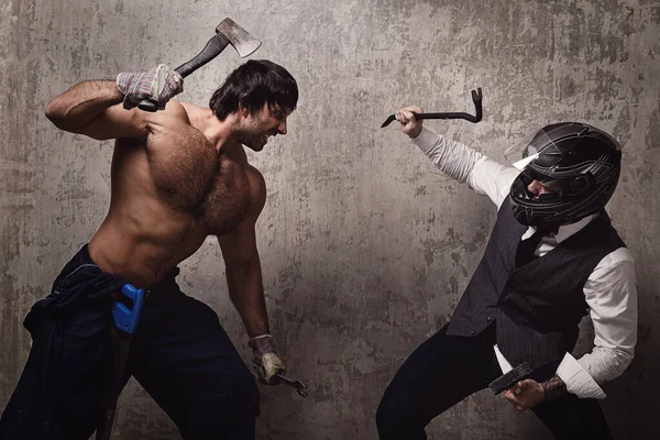 İki adam inşaat aletleriyle kavga ediyor.