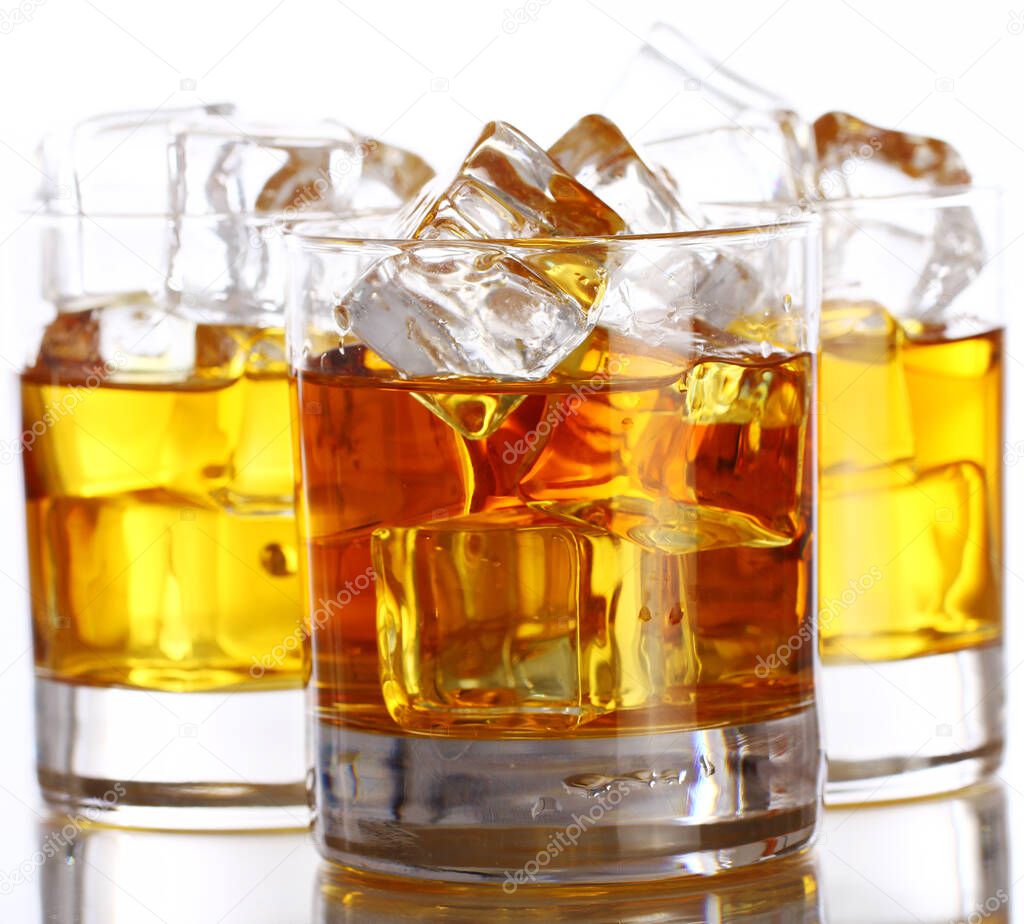 Glasses of cold whiskey with ice isolated over white