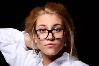 Genç öğrenci kız siyah arka plan üzerine inek gözlük