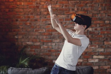 Sanal gerçeklik kulaklığı kullanan genç bir çocuk.