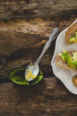 Tahta bir masada nefis avokado sandviçi.