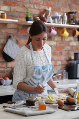 Genç ve güzel bir kadın mutfakta yemek pişiriyor. El yapımı yemek.