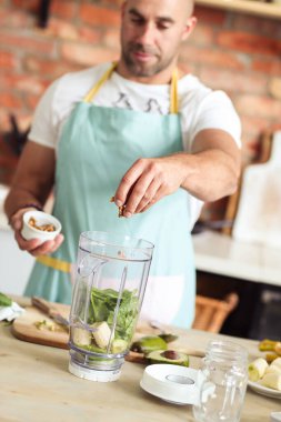 Mutfak. Mutfakta mavi önlüklü bir adam.