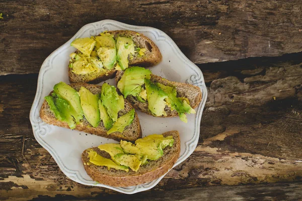 Tahta bir masada nefis avokado sandviçi.