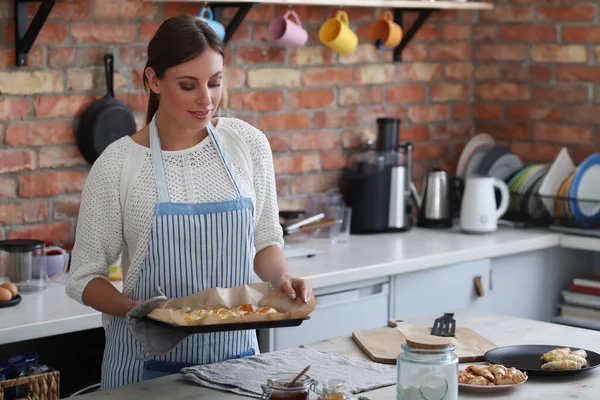 Genç ve güzel bir kadın mutfakta yemek pişiriyor. El yapımı yemek.