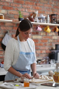 Genç ve güzel bir kadın mutfakta yemek pişiriyor. El yapımı yemek.